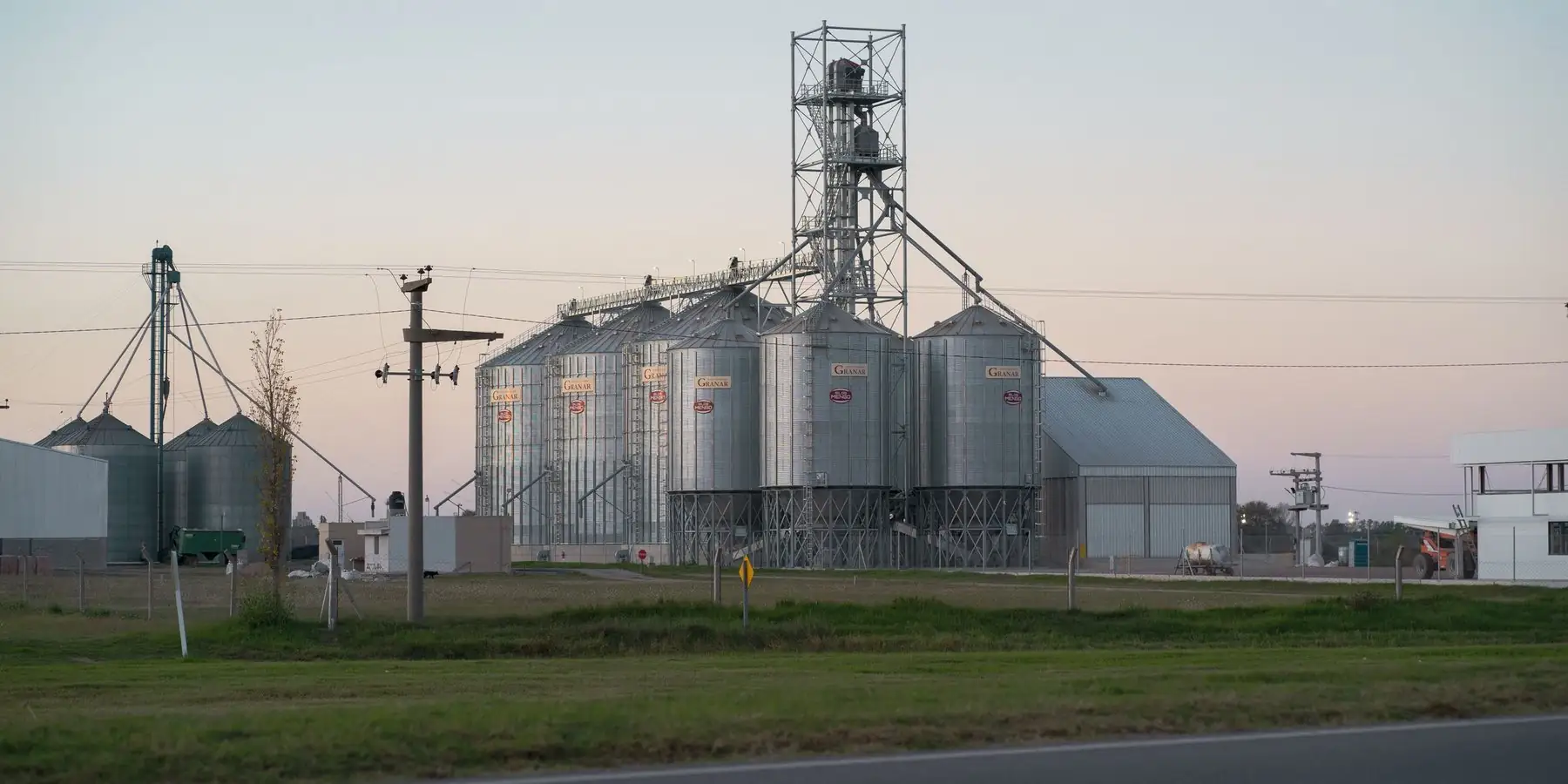 Silos de granos junto a una ruta al atardecer